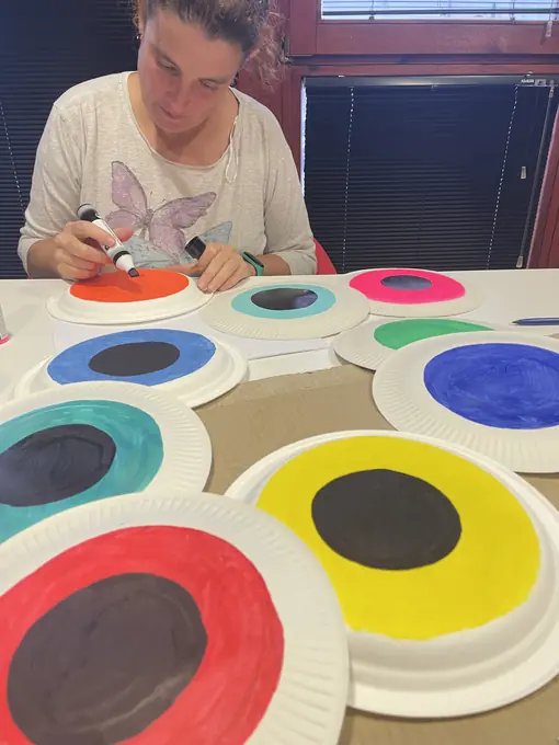 Una voluntaria pinta los ojos de las decoraciones