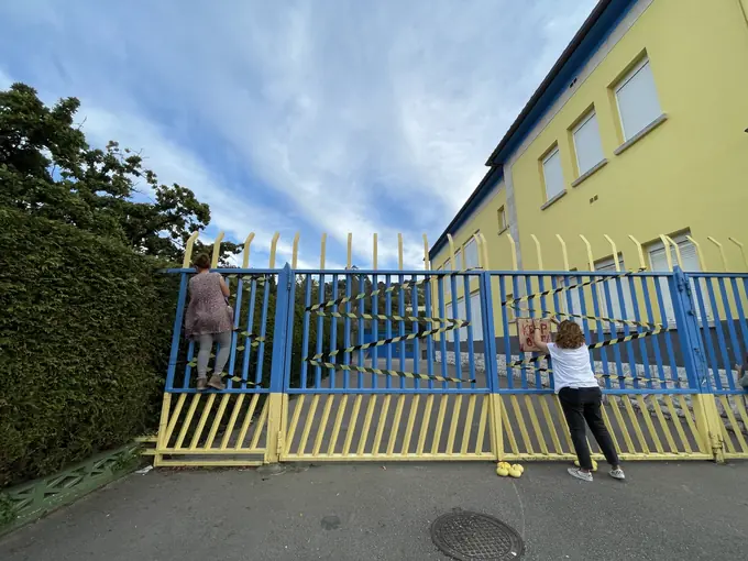 Familias colocando las decoraciones en la verja del colegio