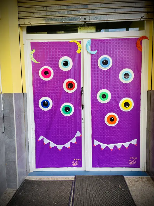 Puertas moradas decoradas con ojos de colores y una sonrisa