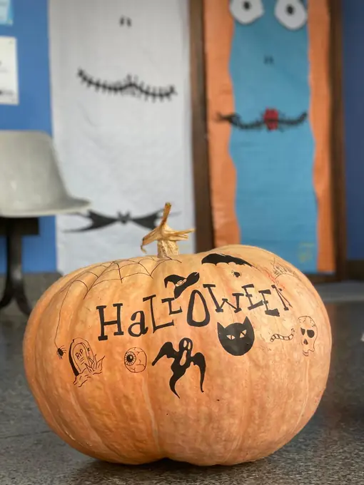 Una calabaza con la palabra Halloween frente a la entrada